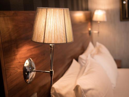 a lamp on a wall next to a bed at Palace Hotel in Peterhead