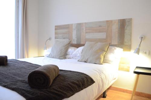 een slaapkamer met een groot bed met witte lakens en kussens bij Poble Sec Apartments in Barcelona