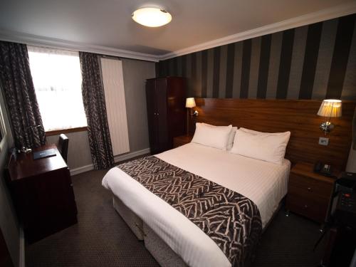 a hotel room with a bed and a window at Palace Hotel in Peterhead