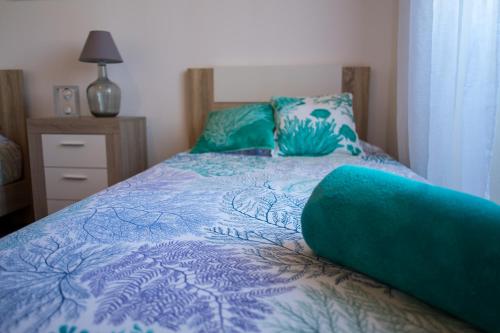 um quarto com uma cama com um edredão azul em Populo Beach House em São Roque