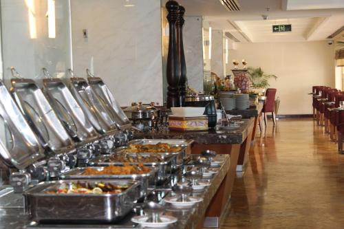 a buffet line with many trays of food at Grand Regency Doha, Trademark Collection by Wyndham in Doha