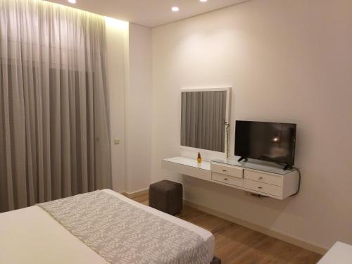 a hotel room with two beds and a flat screen tv at Rustemi in Sarandë