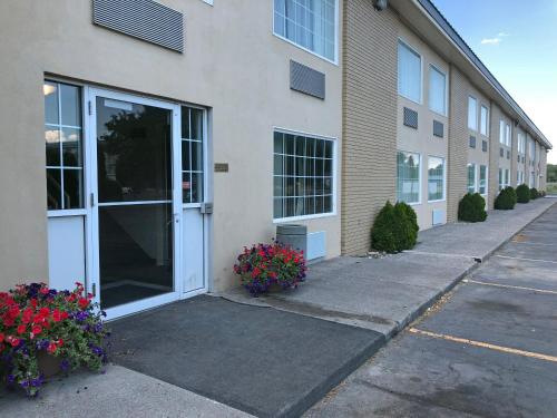 a building with a door and flowers in front of it at FairBridge Extended Stay, a Kitchenette Hotel in Idaho Falls
