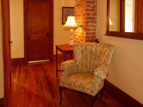 a room with a chair and a table with a lamp at Au Virage B&B in Magog-Orford
