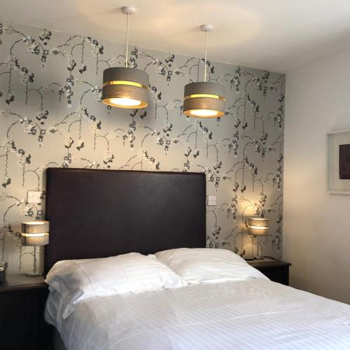 a bedroom with a bed and two lights and a wall at Newton House Oxford in Oxford