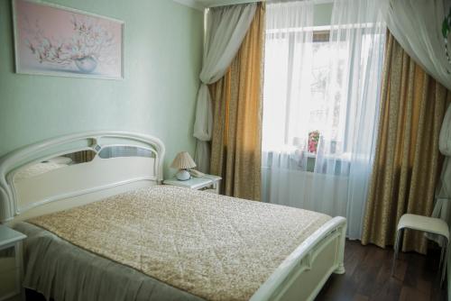 a bedroom with a white bed and a window at Dniprovski Zori in Kremenchuk