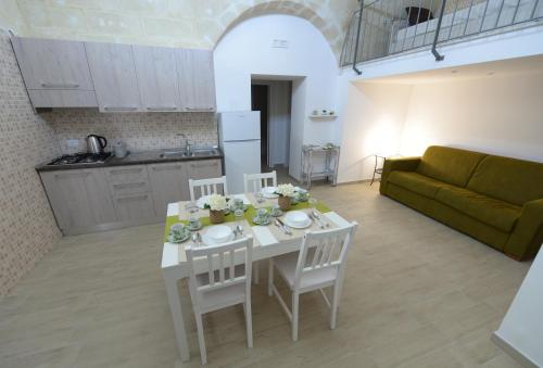 a kitchen and living room with a white table and chairs at Dimora Civitas Severiana in Montescaglioso