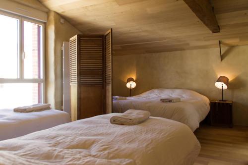two beds in a room with two lamps on at Le Puy Carmin - Chambre d'hôtes avec jacuzzi in Bazoges-en-Paillers
