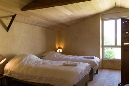 a room with two beds and a window at Le Puy Carmin - Chambre d'hôtes avec jacuzzi in Bazoges-en-Paillers