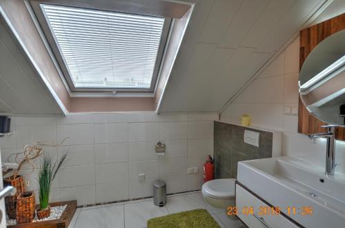 a bathroom with a toilet and a sink and a window at Ferienwohnung"VIP MUNICH ALBATROS DE LUXE" in Kirchheim