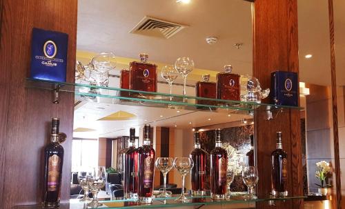 a bar with wine glasses on display in front of a mirror at La Roche Hotel in Erbil