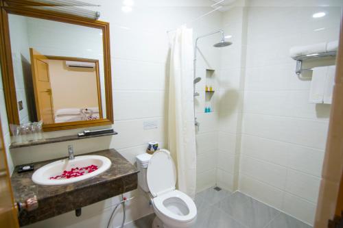 a bathroom with a sink and a toilet and a mirror at The Hotel Umbra Bagan in Bagan
