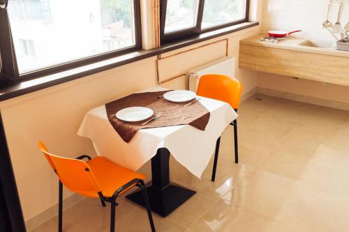 a table and chairs in a room with a kitchen at Francesca Residence in Bucharest