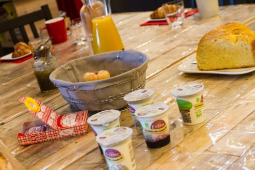 a table with a loaf of bread and a bucket of eggs at Le Puy Carmin - Chambre d'hôtes avec jacuzzi in Bazoges-en-Paillers