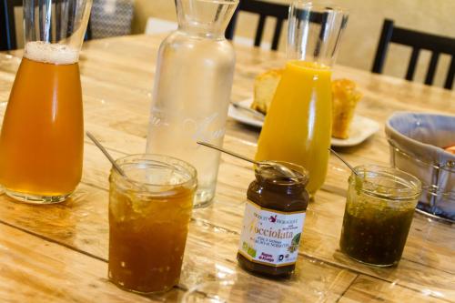 a table with four bottles and glasses of drinks at Le Puy Carmin - Chambre d'hôtes avec jacuzzi in Bazoges-en-Paillers