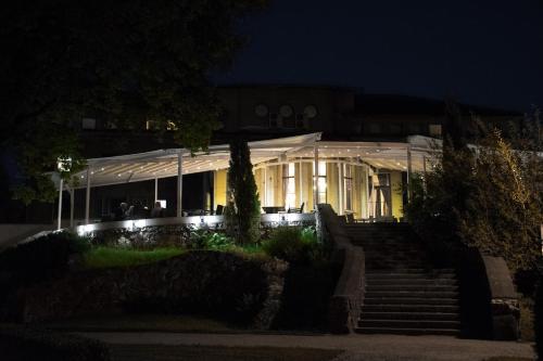 a white building with a marquee at night at Hotel Cēsis in Cēsis