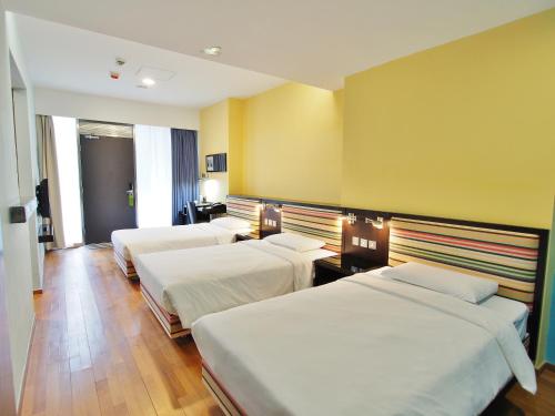 una camera d'albergo con tre letti di Y Loft a Hong Kong