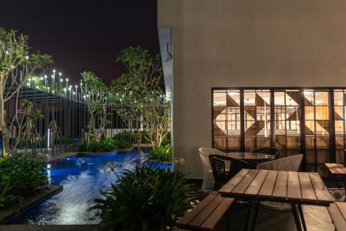 a hotel patio with a swimming pool at night at Ramada Meridin Johor Bahru in Nusajaya