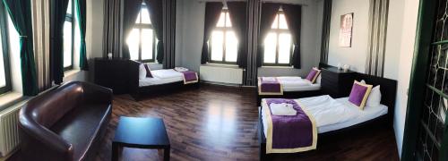 a room with two beds and a couch and windows at Ferienwohnung Alabama in Lutherstadt Wittenberg