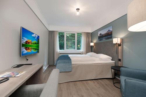 a hotel room with a bed and a desk at Førde Hotel - Unike Hoteller in Førde