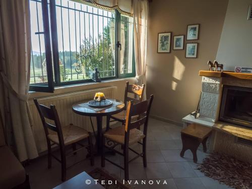 a dining room with a table and chairs and a window at Guesthouse Paralimnia in Kalyvia