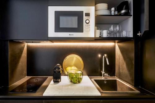 a kitchen counter with a sink and a microwave at The A5 Smart Luxury Studios in Porto