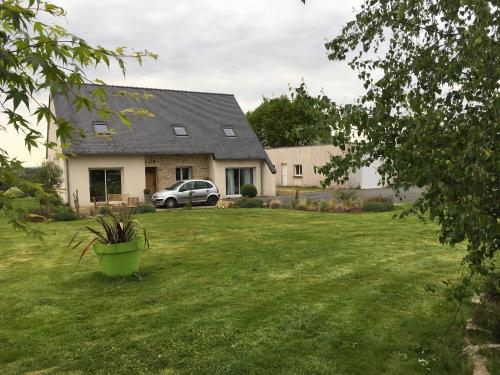 a house with a car parked in a yard at Ti Laouen Karaez in Carhaix-Plouguer