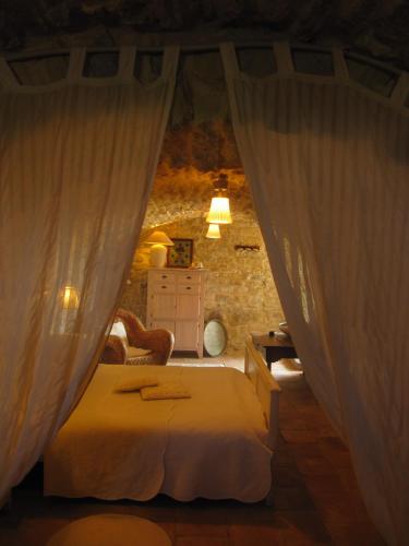 a bedroom with a bed and curtains in a room at La Flor Azul in Grospierres