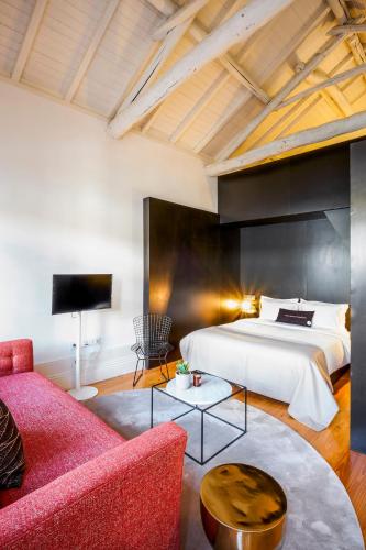 a bedroom with a king sized bed and a red couch at The A5 Smart Luxury Studios in Porto