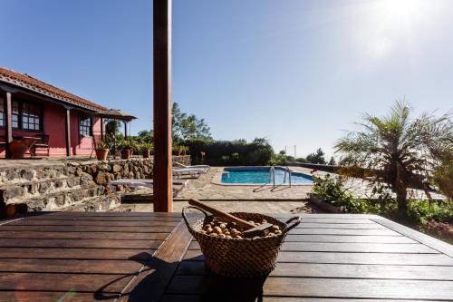 una mesa de picnic con una cesta junto a una piscina en La Verada, en Puntagorda