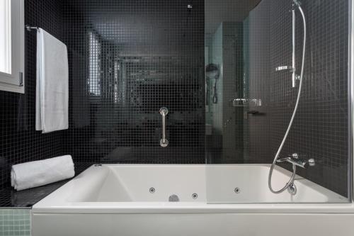 a bathroom with a bath tub with a glass shower at Exe Plaza Catalunya in Barcelona