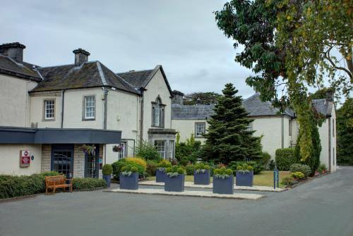 a house with potted plants in front of it at Best Western Plus Dunfermline Crossford Keavil House Hotel in Dunfermline
