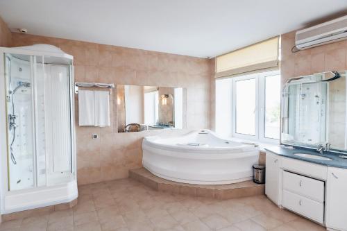 y baño grande con bañera grande y ducha. en Nikolaevsky Hotel, en Vólogda
