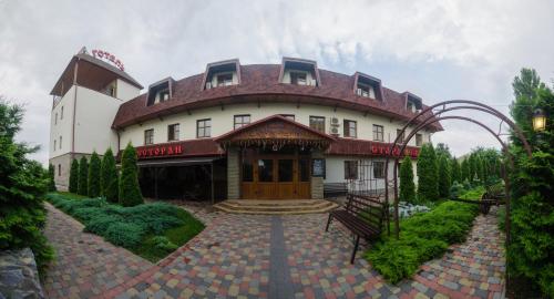 a large white building with a red roof at Stara Vezha Hotel in Boryspilʼ