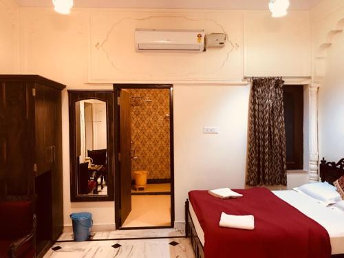 a hotel room with a bed and a mirror at Hotel Kalyan in Jaipur