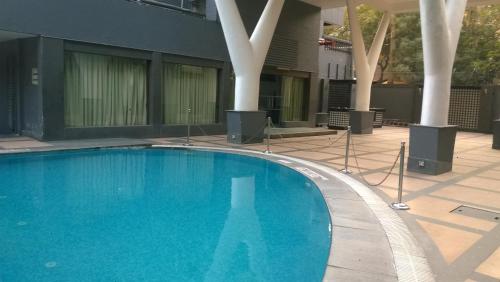 uma grande piscina azul em frente a um edifício em Park Inn by Radisson,South Delhi em Nova Deli
