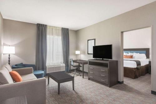 a hotel room with a bed and a television at Wingate by Wyndham Lubbock in Lubbock