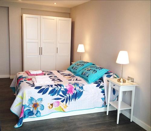 een slaapkamer met een bed en een tafel met een lamp bij ESCALERA 14 in Gijón