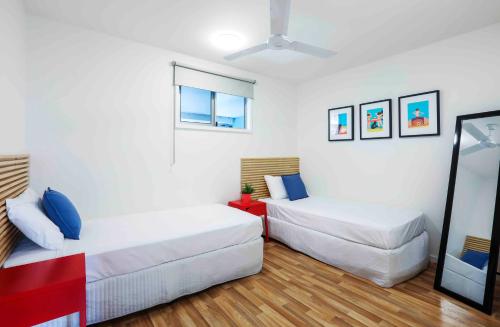 a bedroom with two beds and a window at Sandbox Apartments in Gold Coast