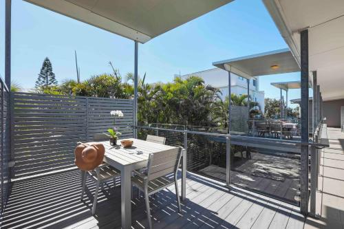 a patio with a table and chairs on a deck at Sandbox Apartments in Gold Coast