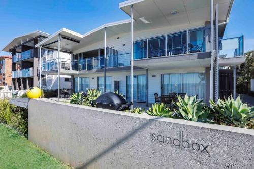 a large house with asbmok sign in front of it at Sandbox Apartments in Gold Coast