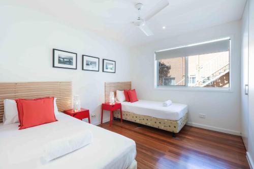 a white room with two beds and a window at Sandbox Apartments in Gold Coast