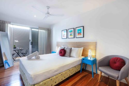 a bedroom with a large bed and a chair at Sandbox Apartments in Gold Coast