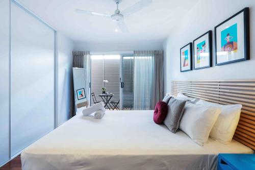 a bedroom with a large white bed with white pillows at Sandbox Apartments in Gold Coast