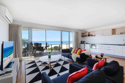 a living room filled with furniture and a tv at Sandbox Apartments in Gold Coast