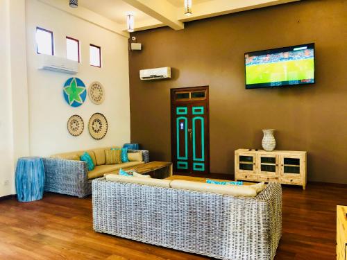 a living room with two couches and a flat screen tv at Thaproban Pavilion Waves in Unawatuna
