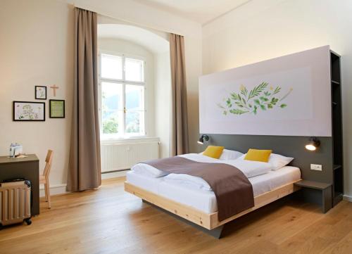 a bedroom with a bed and a large window at JUFA Hotel Stift Gurk in Gurk