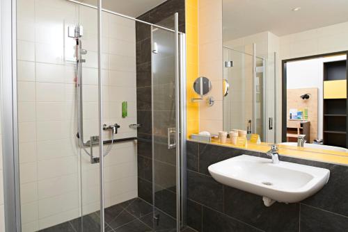 a bathroom with a sink and a glass shower at JUFA Hotel Stift Gurk in Gurk