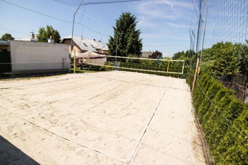 a tennis court in front of a fence at Penzion-Cukroška in Hlušovice