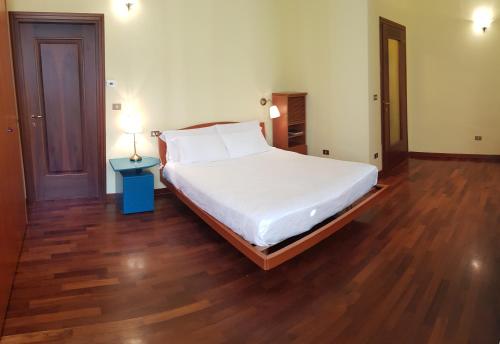 - une chambre avec un grand lit et du parquet dans l'établissement B&B- Il Roma, à Sulmona